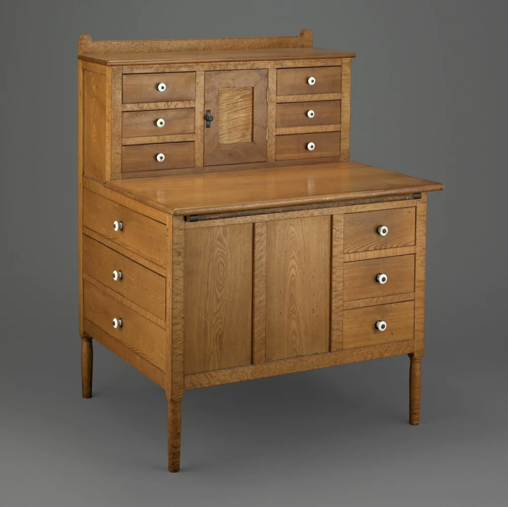 A wooden Shaker sewing desk with drawers and an open work surface